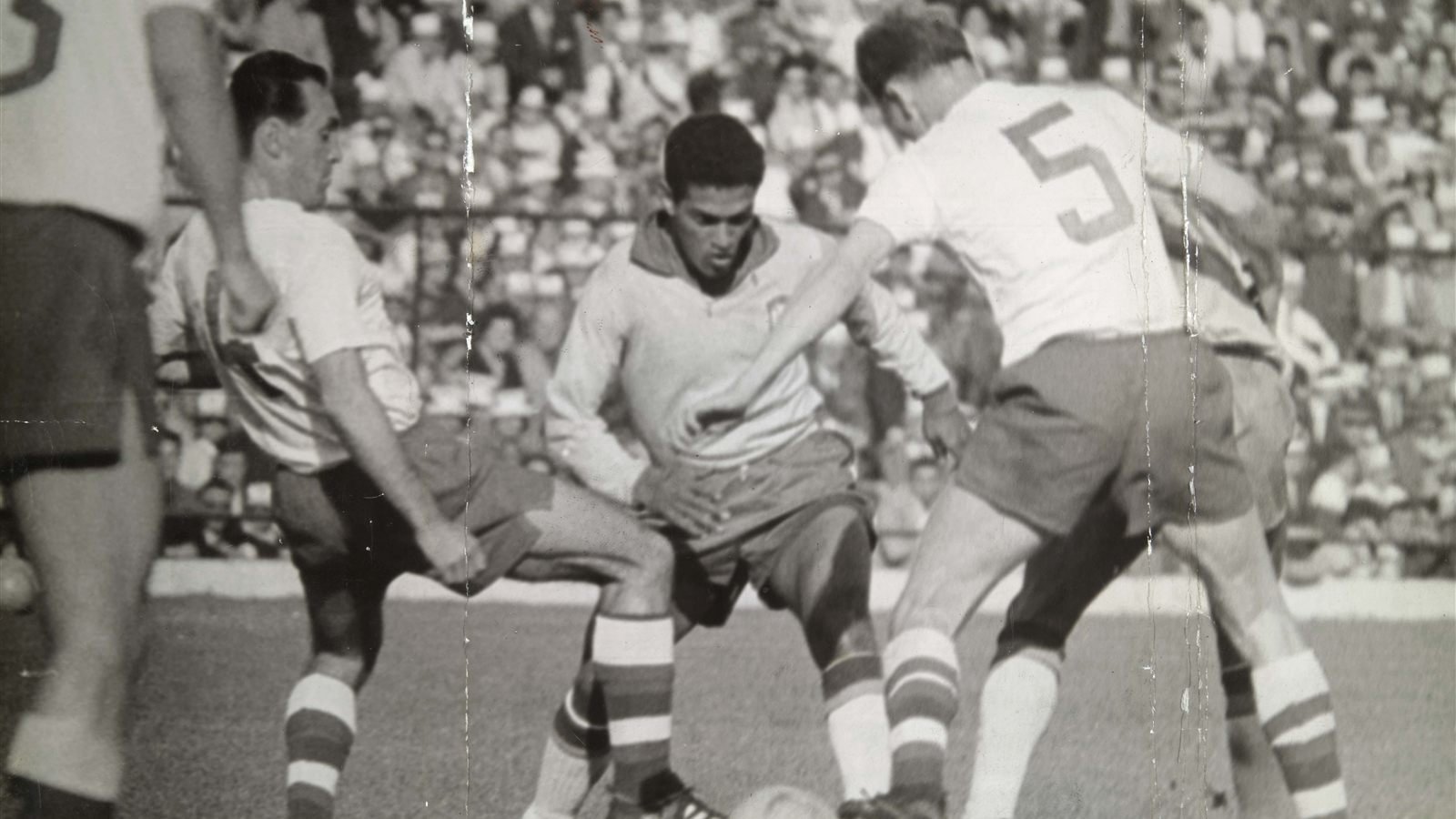 Garrincha carries the ball surrounded by three defenders during a 1962 World Cup match in Chile